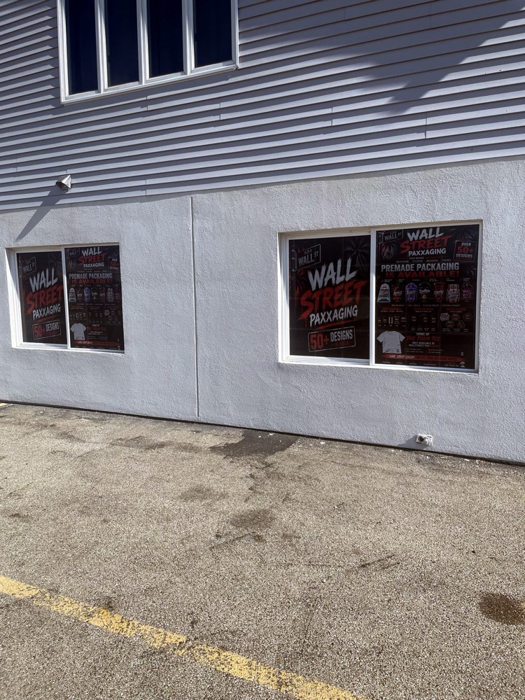 Bold printed window decals covering a packaging shop's front windows
